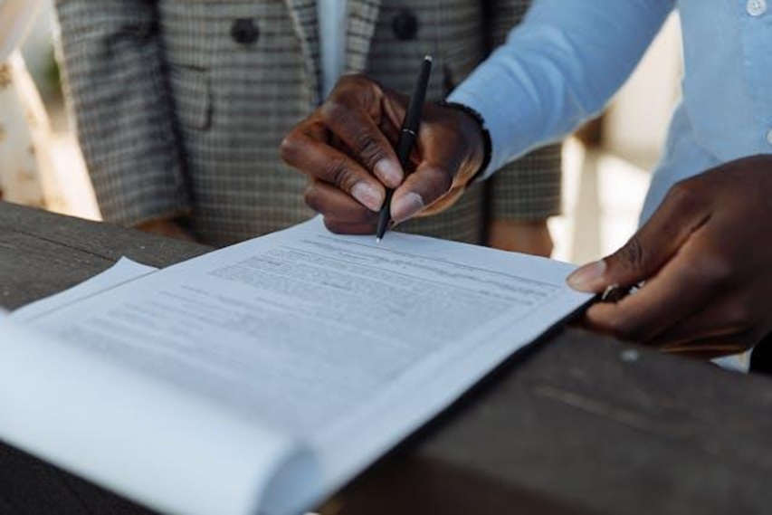 a hand signing a documents